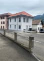 Building, red tiled roof, glass windows, metal fence, driveway