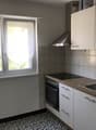 white cabinets, white countertop, stainless steel sink, oven and stove, range hood, tiled wall, window with curtain