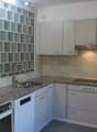 modern kitchen with granite countertops, stainless steel sink, dishwasher, electric stove, cabinets, power outlets, and a power switch