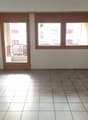 empty room, white tiles, wooden door, windows, balcony