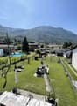 Complex of houses with swimming pool, garden area, and open view of the mountain.