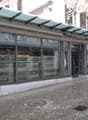 Facade of building with a canopy, glass windows, and signage.
