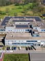 Industrial building, rooftop solar panels, multiple floors, large parking lot