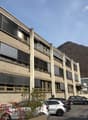 large modern building, parking, surrounded by mountains