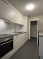 kitchen with integrated appliances and countertops, white cupboards and drawers, and a floor with tiles