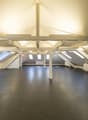 Empty attic room, wooden beams, skylights, radiators, white walls, black floor