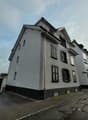 3 story building, gray exterior, multiple windows, two garages