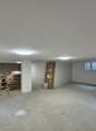 empty room with a ceiling and lights, a small white pillar, ladders and tools