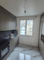 modern kitchen with black and grey colors, electric stove, sink, cabinets, marbled flooring