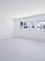 white walls, white floor, large windows, modern radiator, view to street