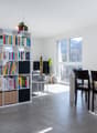 Dining area with a large bookshelf, dining table, chairs, and a view of the mountains