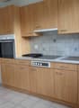 Spacious kitchen with wooden cabinets, tiled backsplash, built-in oven, and dishwasher