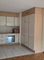 a kitchen with wooden countertops, an oven, a refrigerator, and a washing machine