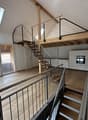 wooden floors, skylight, white walls, metal handrails, stairs, kitchen