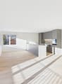 open plan living room and kitchen, large windows, balcony, hardwood floor, gray cabinetry