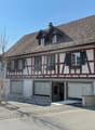 2 story house, brown roof, white and brown walls, garage