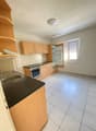 empty kitchen, white tiles, wooden cabinets, counter, sink, oven, refrigerator