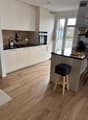 white kitchen, wood floor, island, oven, sink, modern appliances