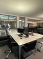 modern office space with desk, chairs, computers, large windows, tiled floor, lamps