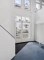 White walls, blue carpet, white radiator, glass doors, metal handrail