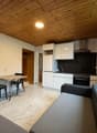 open-plan living room and kitchen, large window, wooden ceiling, dining table, sofa, marble flooring, refrigerator, oven