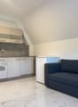 Small kitchen with integrated appliances, tile flooring, modern furniture, sofa bed