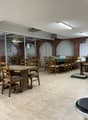 Wooden tables and chairs, tiled floor, brick wall, glass wall, tables in another room