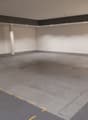 Empty parking lot, white walls, gray floor, white ceiling, yellow line markings, pillar