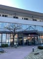 2-story commercial building with large glass windows, UBS bank signage, and a paved parking area in front