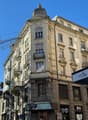 Facade of a building, three floors, several balconies, windows with shutters