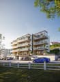 Modern apartment building with multiple balconies, glass railings, and a ground floor entrance.