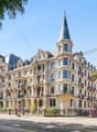Ornate classical building, several floors, balcony on second floor, turrets