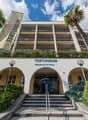 multi-story building, entrance, staircase, flag, palms, entrance sign