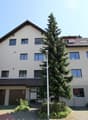 3 story house, beige exterior, multiple windows, garage, car parked in front