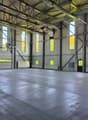 large open space, metal beams, large windows, concrete floor, industrial look