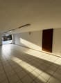 empty room, white tiles, fluorescent lighting, doorway