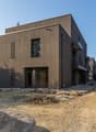 Modern house, brown wooden exterior, large windows, balcony, under construction