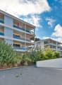 multi-storey building, balconies, underground parking, paved driveway