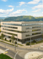 Office building with multiple floors, glass windows, located near a road intersection, surrounded by greenery and mountains in the background.