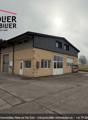 two story building, tan walls, black roof, white doors, windows, garage doors