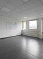 open room, large windows, whiteboard on wall, white flooring