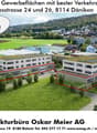 Two commercial buildings, Birchstrasse 24 and 26, Dänikon, availability from Autumn 2027, well-connected with transportation, flat terrain, solar panels on roofs, red-outlined areas on buildings, green landscaping, surrounding houses and buildings, distan