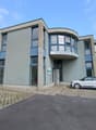 Office building, modern design, glass facade, entrance, small car parked in front