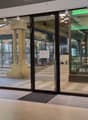 glass doors, wooden floor, white walls, plants, tables, chairs, lamps