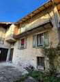 Two story house with stone wall, balcony, garage