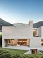 modern architectural design, made of white stone, large windows, large garden, mountains in the background