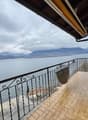 wooden tiled floor, balcony rail, chair, lake view, mountains