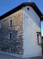 2 story house, stone exterior, white interior, multiple windows, balcony on second floor