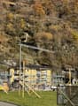 Building under construction, steel scaffolding, solar panels, yellow building, tanks, road