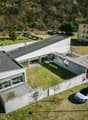 modern house, multiple levels, covered parking, front garden, trees, white exterior